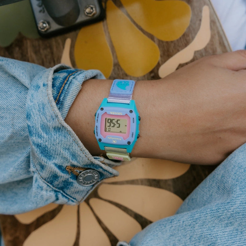 close up of blue watch on wrist with pink accents