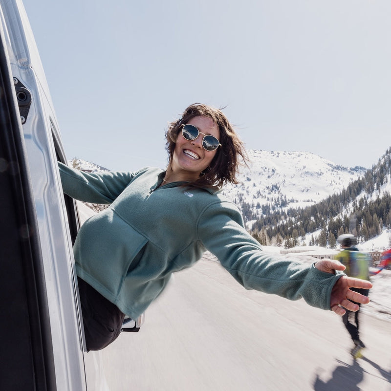 Women with body outside of window and hand up in the air