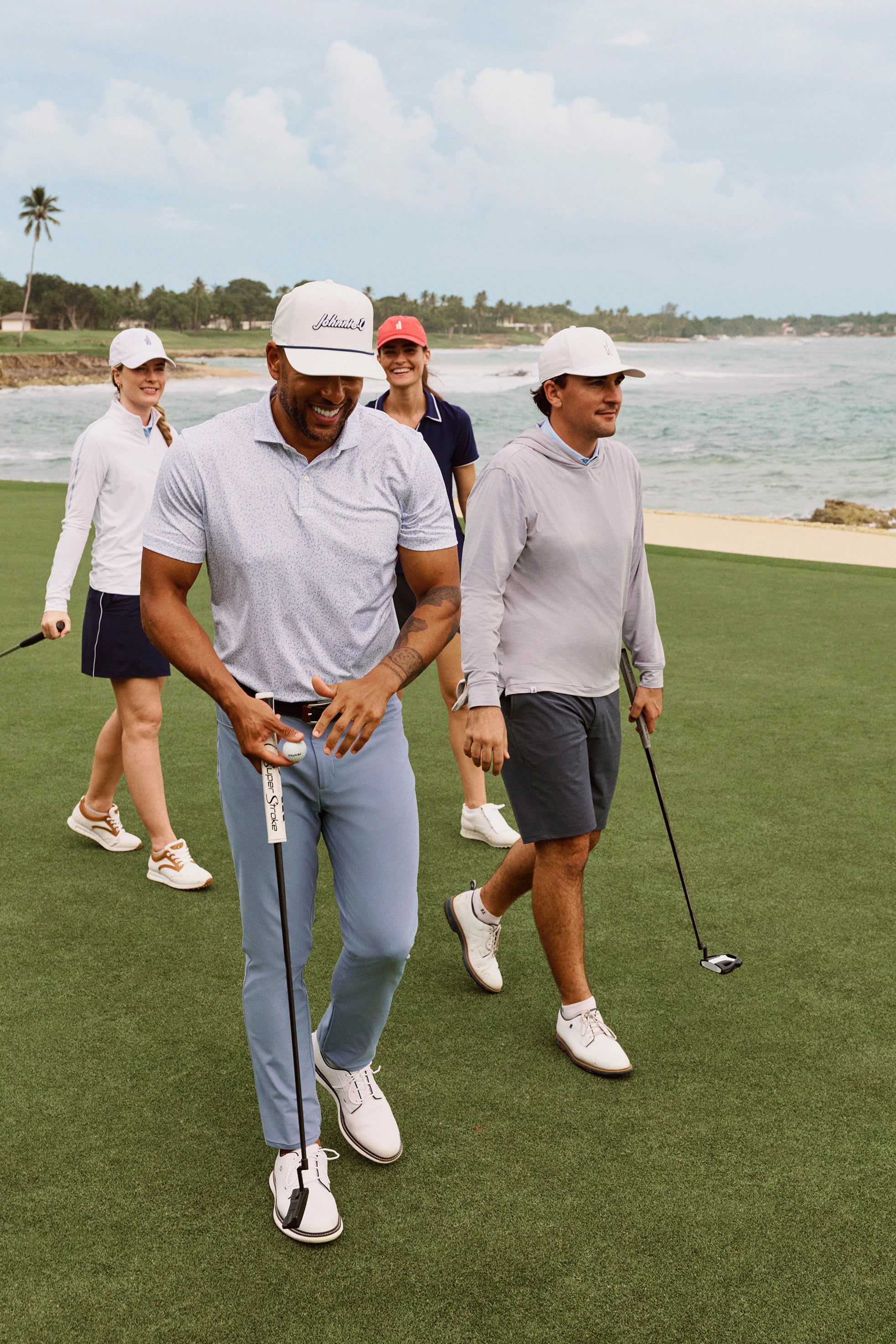 Group of people playing golf on a green course with a scenic background.