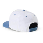 White structured baseball cap with a light blue flat brim and matching blue button details, shown from a three-quarters rear angle on a white background.