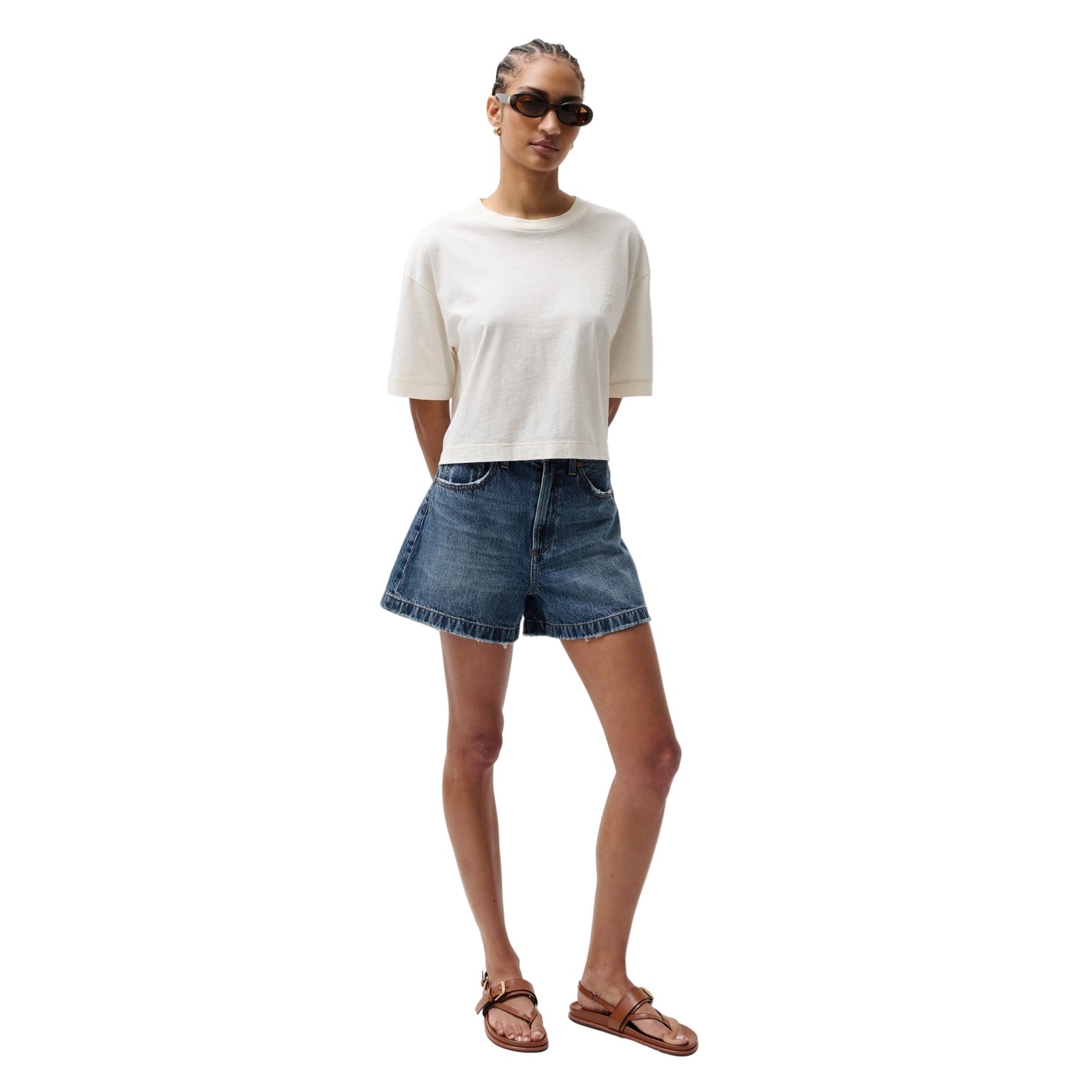 Woman wearing a white t-shirt and denim shorts on a white background
