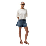 Woman wearing a white t-shirt and denim shorts on a white background