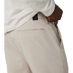 Beige pants with a brand label on a white background