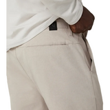 Beige pants with a brand label on a white background