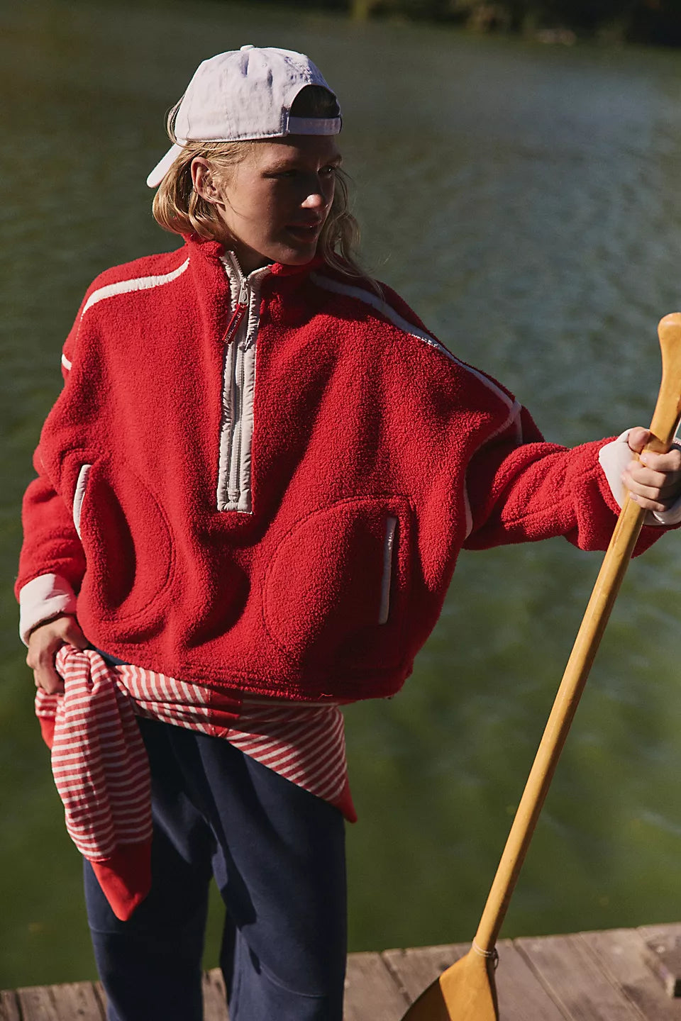 women in a red pullover fleece standing in front of water