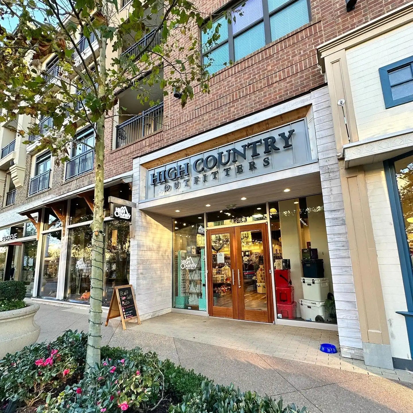 ’High Country Outfitters’ store with a wooden double door entrance.