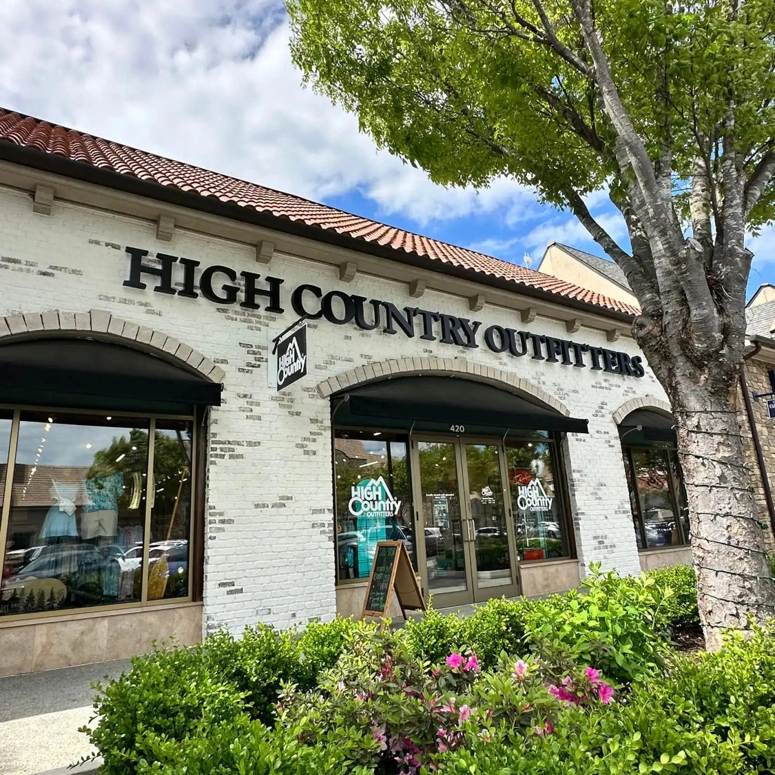 High Country Outfitters storefront with Spanish-style arched entryway and terra cotta roof tiles.